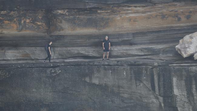 Tourists risking their lives on narrow rock ledges at Diamond Headland in Vaucluse. Photo: Tim Pascoe