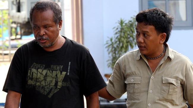 Abraham Louhenapessy, left, is escorted back to jail in Merak, Banten province in 2010.