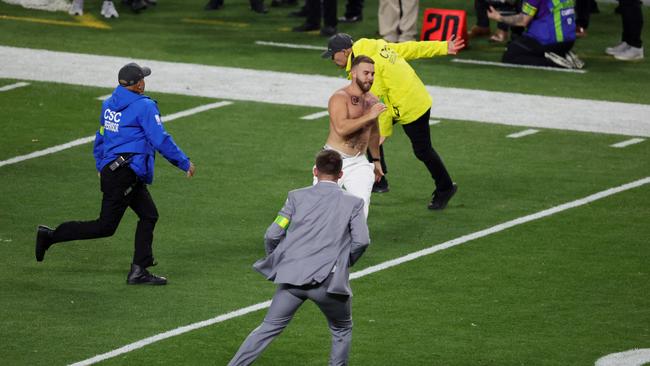 A streaker does his best to evade authorities. (Photo by Ethan Miller / GETTY IMAGES NORTH AMERICA / Getty Images via AFP)