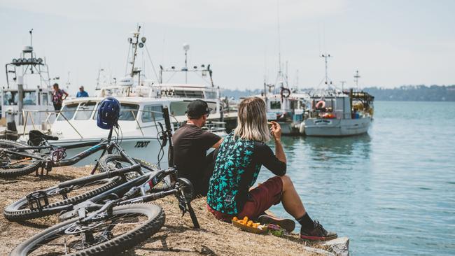 Enjoying fish and chips by the shore at St Helens, Tasmania. Picture: Stu Gibson