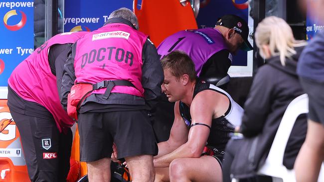 Ollie Wines in the hands of Doctors on the bench during the clash against Hawthorn. (Photo by Sarah Reed/AFL Photos via Getty Images)