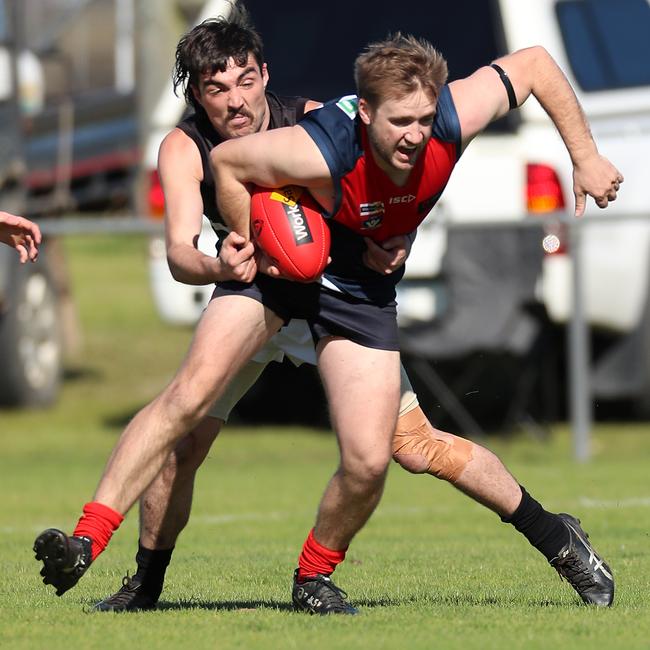 Swift’s Creek’s Ben Commins is tackled by Omeo-Benambra’s Jordan Robertson.