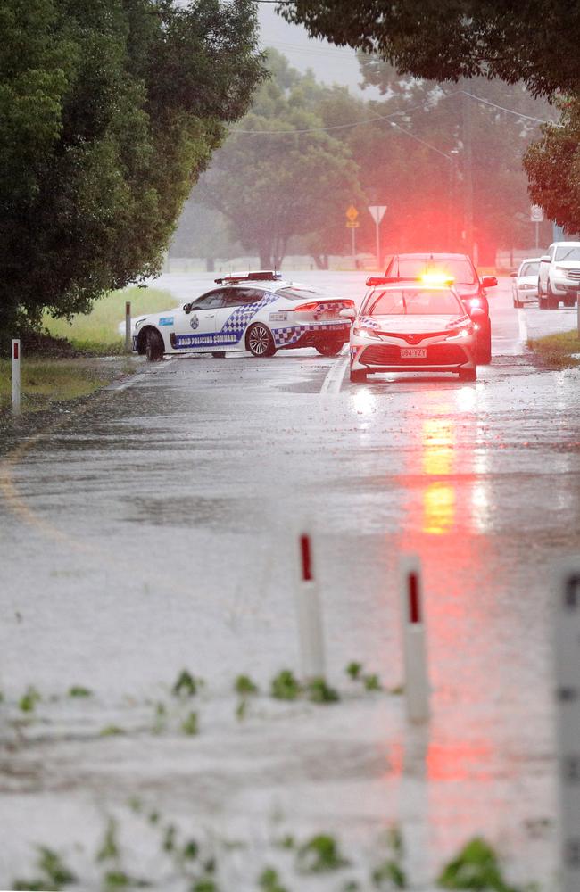 Queensland uniformed Police block the road on Tallebudgera Connection Road Tallebudgera at the back of Currumbin Creek after torrential rain over night caused the creek to break its banks. NCA NewsWire / Scott Powick