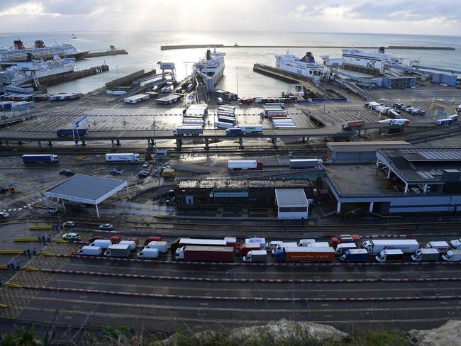 Goods vehicles queue beside parked emergency services vehicles close to the entrance to the Port of Dover, in Dover on the south-east coast of England, on December 24. France and Britain reopened cross-Channel travel on Wednesday after a 48-hour ban to curb the spread of a new coronavirus variant.