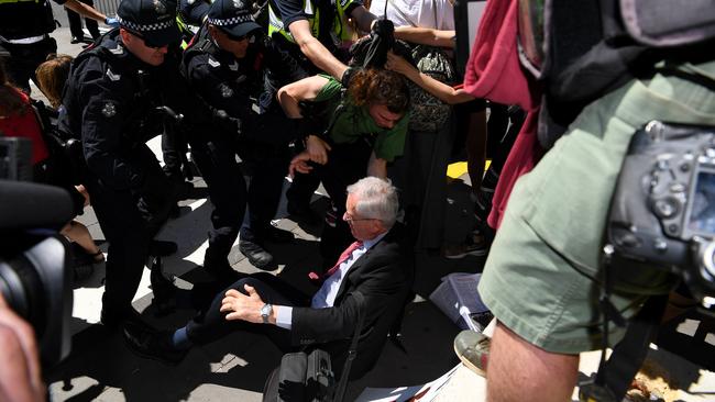 Police intervene to protect an man from protesters outside the Melbourne Exhibition and Convention Centre.