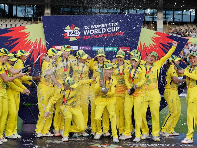 TOPSHOT - Australia's captain Meg Lanning (C) holds the trophy with her teammates after they won the final T20 women's World Cup cricket match against South Africa at Newlands Stadium in Cape Town on February 26, 2023. (Photo by Marco Longari / AFP)