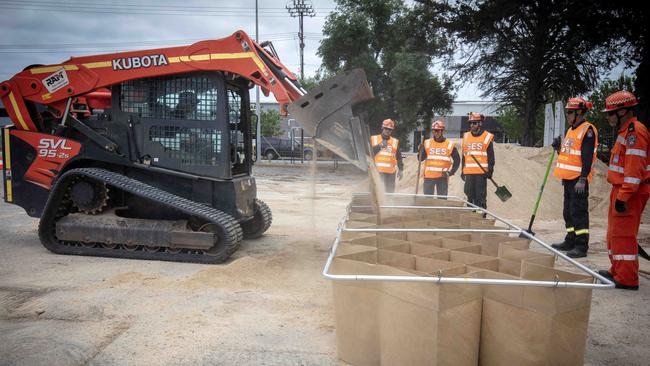 SES Netley workers demonstrate the speed and ease of filling a DefenCell with sand, which can be used as a levee during flooding. Picture: NCA NewsWire / Emma Brasier