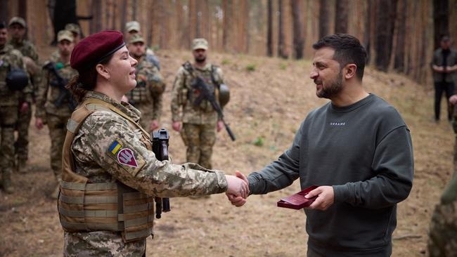 Volodymyr Zelensky presents an award to a servicewoman in the Kharkiv region on Tuesday. Picture: Ukrainian Presidential Press Service via AFP