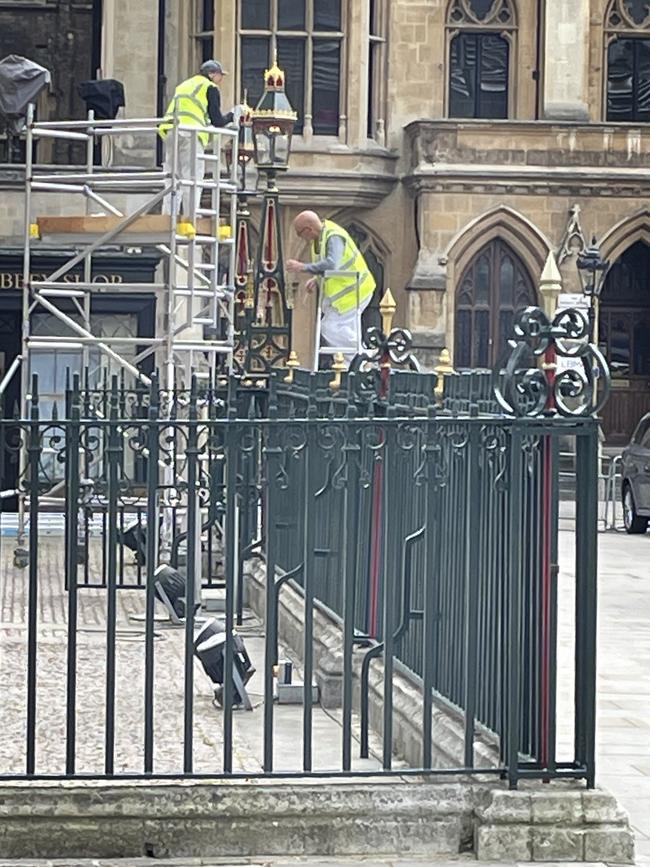 Painters apply last-minute touches outside Westminster Abbey. Picture: Cameron Stewart