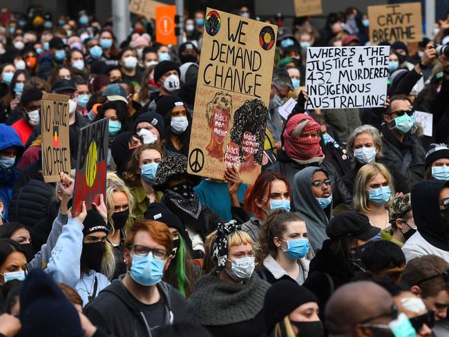 People hold up placards at a Black Lives Matter protest to express solidarity with US protestors in Melbourne on June 6, 2020 and demand an end to frequent Aboriginal deaths in custody in Australia. - Tens of thousands of Australians defied government calls to stay at home on June 6, spilling onto the streets for Black Lives Matter protests in major towns and cities across the country. (Photo by William WEST / AFP)