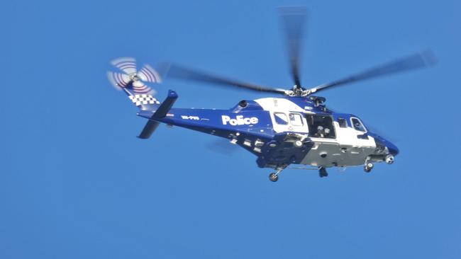 A police helicopter circles above Barwon Heads. Picture: Kelly Fry