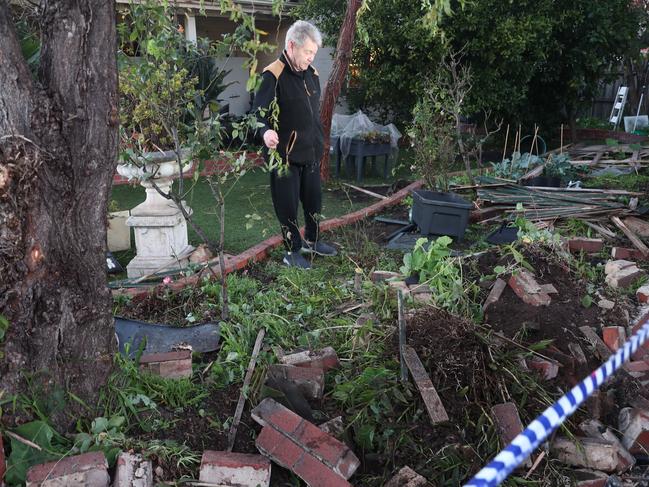 A resident inspects the damage his front yard. Picture: David Crosling