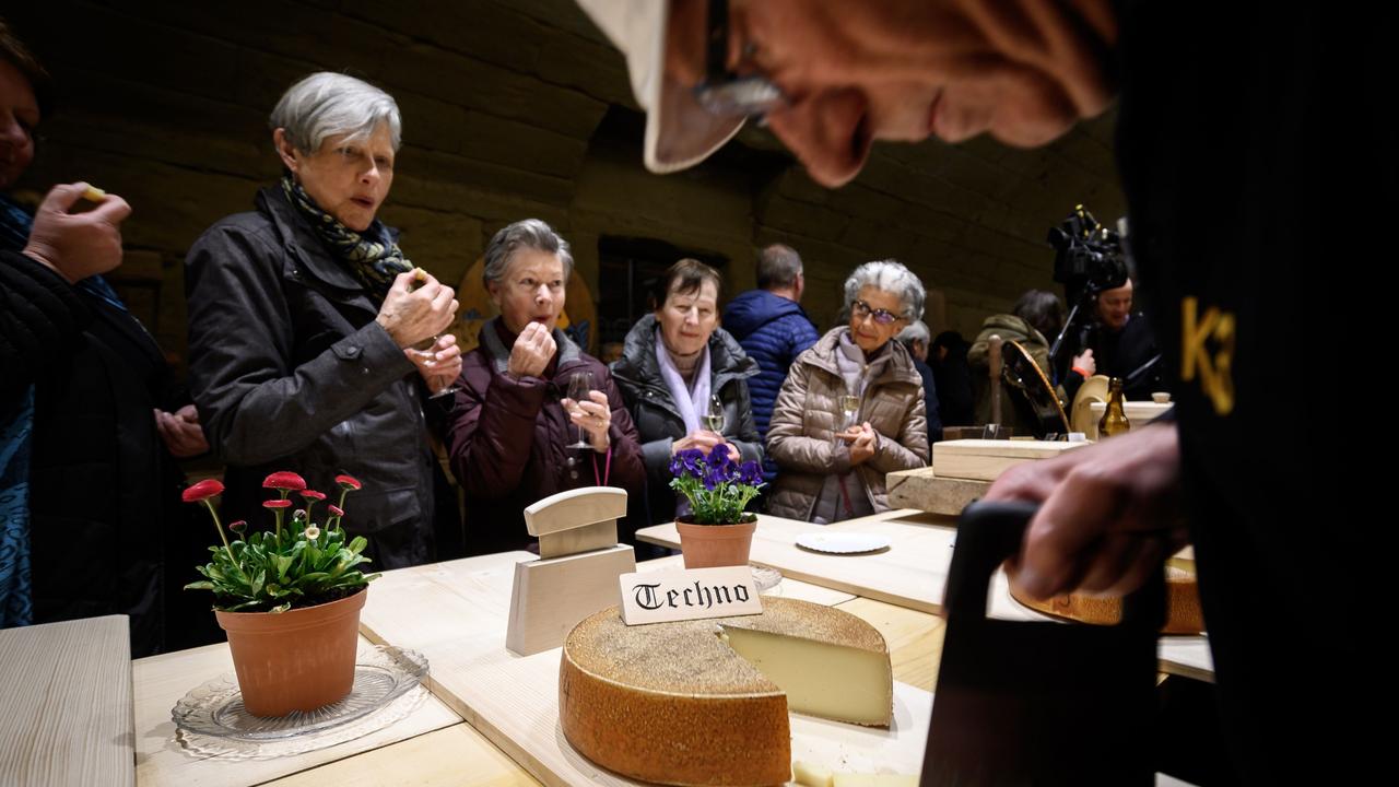 People taste a cheese that has been matured for six months with techno music. Picture: AFP