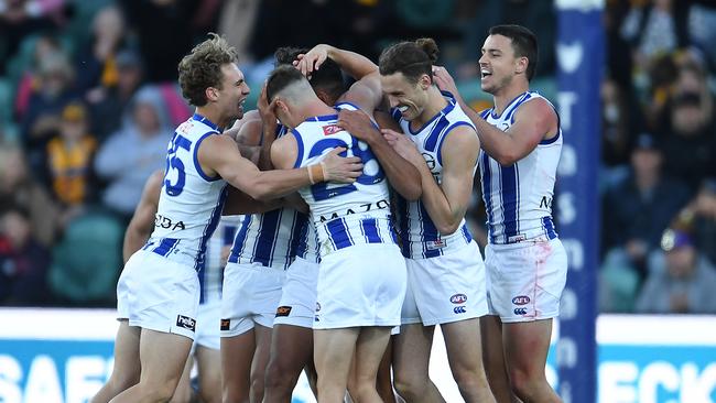 LAUNCESTON, AUSTRALIA - MAY 15: Tarryn Thomas of the Kangaroos is congratulated by his teammates after a goal during the round 9 AFL match between the Hawthorn Hawks and the North Melbourne Kangaroos at University of Tasmania Stadium on May 15, 2021 in Launceston, Australia. (Photo by Steve Bell/Getty Images)