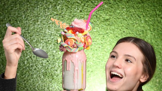 'Sugar Buns’ staff member Ally Kilpatrick with one of the Hampton Park cafe’s the towering milkshake creations. Picture: Jason Sammon.