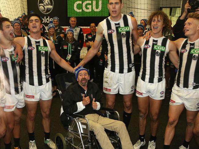 Mason Cox (centre) with MND sufferer Murray Swinton join in the club song after the big win over the Dees. Pic: Michael Klein