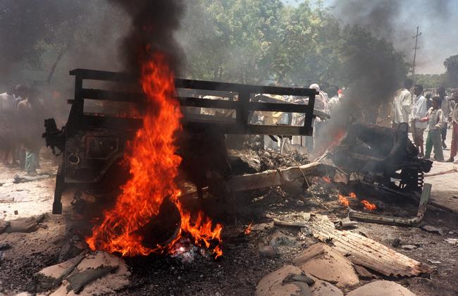 A jeep burns in a Mogadishu street after it was destroyed by a remote-controlled bomb injuring three US servicemen, on October 3, 1993. Two US helicopters were also shot down. Picture: AFP