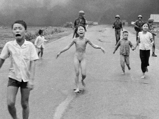 South Vietnamese forces follow after terrified children, including 9-year-old Kim Phuc, center, as they run down Route 1 near Trang Bang after an aerial napalm attack on suspected Viet Cong hiding places, June 8, 1972. A South Vietnamese plane accidentally dropped its flaming napalm on South Vietnamese troops and civilians. The terrified girl had ripped off her burning clothes while fleeing. The children from left to right are: Phan Thanh Tam, younger brother of Kim Phuc, who lost an eye, Phan Thanh Phouc, youngest brother of Kim Phuc, Kim Phuc, and Kim's cousins Ho Van Bon, and Ho Thi Ting. Behind them are soldiers of the Vietnam Army 25th Division. (AP Photo/Nick Ut)