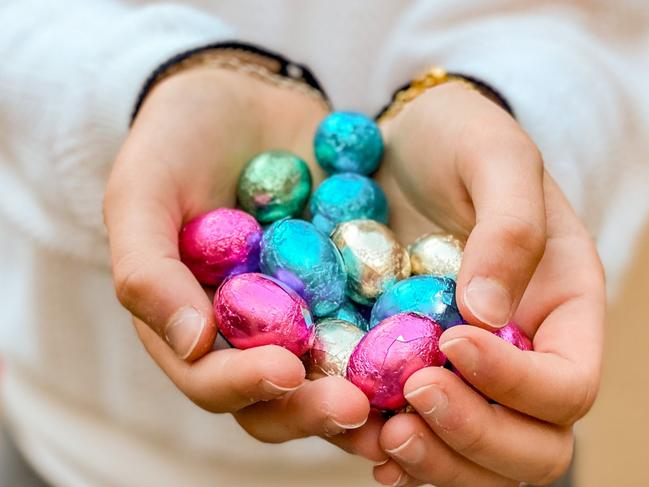 Girl holding chocolate easter eggs with her hands on easter egg hunt.Photo - istockescape 27 march 2022staff picks