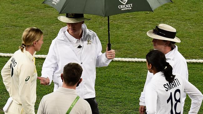 Smriti Mandhana and Meg Lanning speak to the umpires during a rain delay. Picture: Getty Images