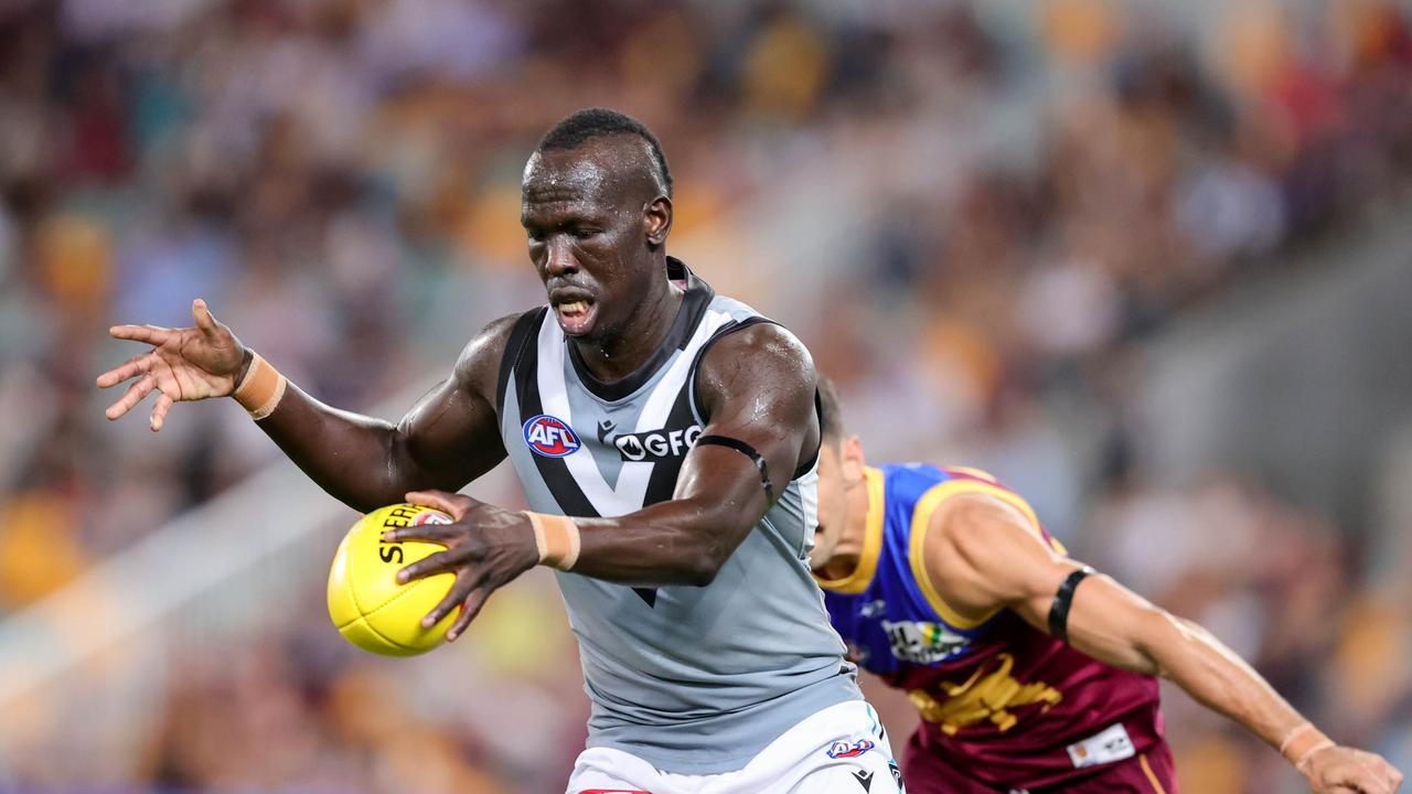 BRISBANE, AUSTRALIA - MARCH 19: Aliir Aliir of the Power kicks the ball during the 2022 AFL Round 01 match between the Brisbane Lions and the Port Adelaide Power at The Gabba on March 19, 2022 In Brisbane, Australia. (Photo by Russell Freeman/AFL Photos via Getty Images)