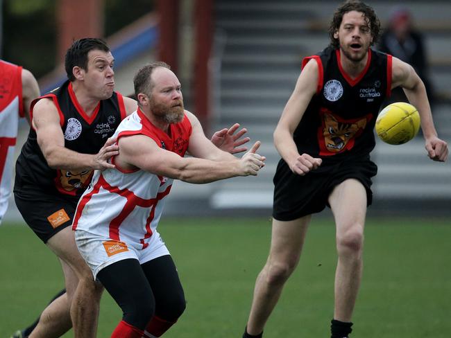 ABC morning presenter Leon Compton feeds out a handpass in last year’s match. Picture: LUKE BOWDEN