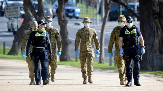 Police and ADF personnel patrol the Tan as Melbourne moves towards stage 4 restrictions. Picture: NCA NewsWire / Andrew Henshaw