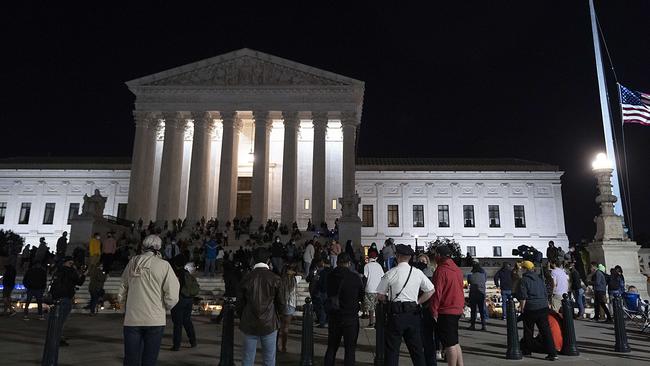 The national flag flies at half staff as people gather to mourn the passing of Supreme Court Justice Ruth Bader Ginsburg at the steps in front of the Supreme Court on September 18 in Washington.