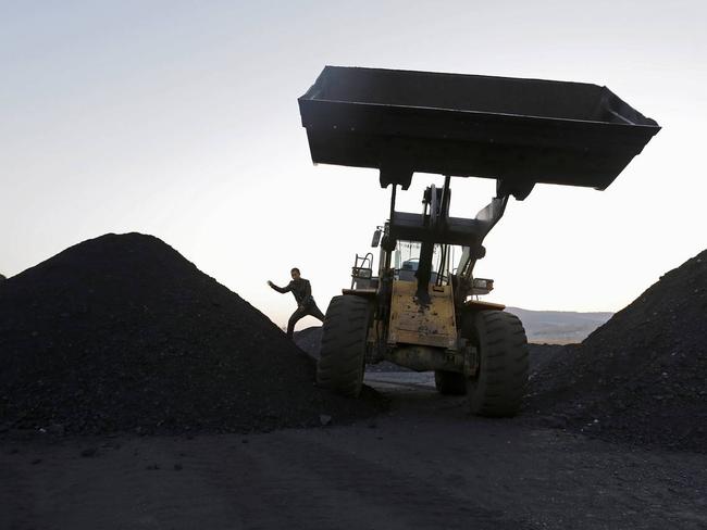 A driver jumps off a loading vehicle at a coal depot on the outskirts of Jixi, in Heilongjiang province, China, Oct. 23, 2015. PHOTO: JASON LEE/REUTERS