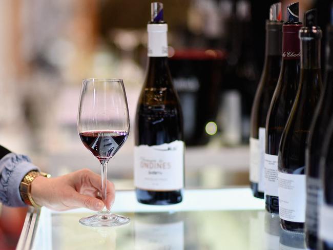 (FILES) An exhibitor swirls a glass of red wine during the Vinexpo at Javits Center on March 2, 2020 in New York City. As President-elect Donald Trump vows sweeping tariffs on even America's close partners once in office, US wine merchants and restaurateurs are watching with trepidation -- and pushing for exclusions they say will protect small businesses. (Photo by Angela Weiss / AFP)