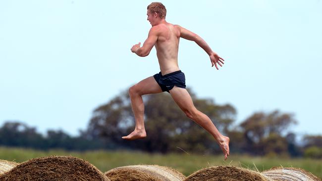 Tom Clurey runs across hay bales at the family farm ahead of the 2012 AFL draft.