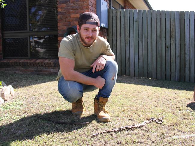 Boyne Island's James 'Jimmy' Canhan with the withered remains of a brown snake that repeatedly stuck at him while doing 100km/h on the Dawson Highway. He plans to keep the head and make it into a gear knob as a momento. Picture: Rodney Stevens