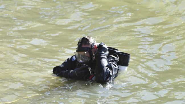 A police diver searches a reservoir in country Victoria. Picture: Ian Wilson