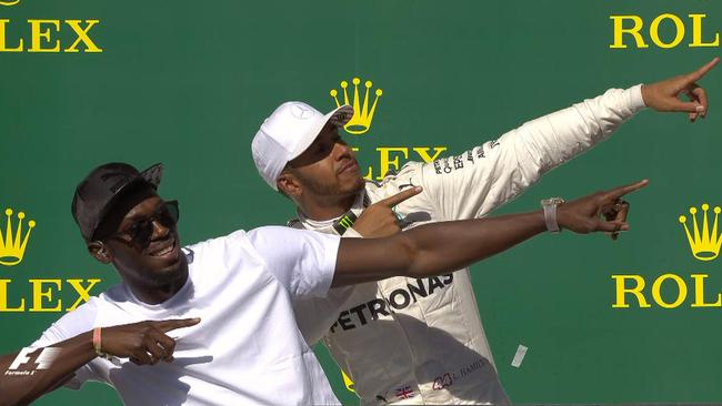 Lewis Hamilton celebrates on the podium with Usain Bolt after winning the United States Grand Prix.