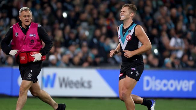 Dan Houston winces in pain from a shoulder injury. Picture: James Elsby/AFL Photos/Getty Images