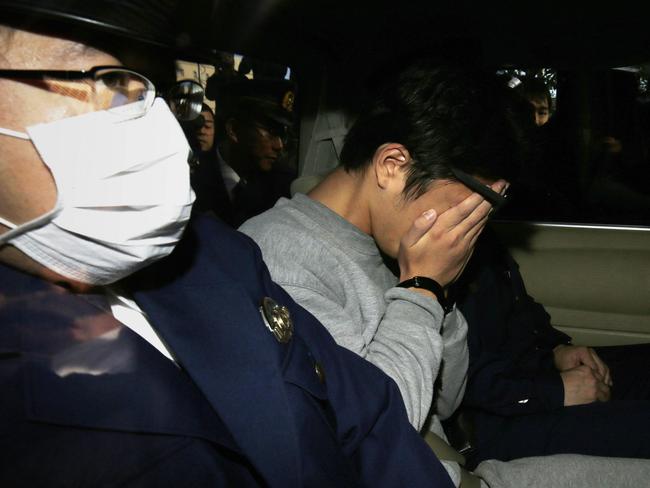 Takahiro Shiraishi covers his face under arrest after police found the decaying remains of nine people in his Tokyo flat. Picture: AFP.