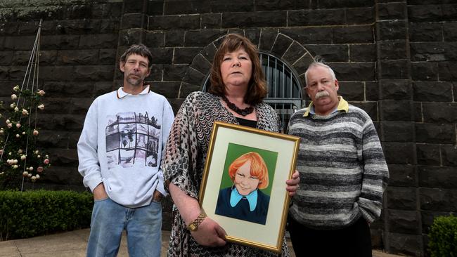 Chris Cowie, Sue Cowie and Steve Cowie outside Pentridge Prison with a picture of their brother Greg Cowie who was murdered by Reginald Edward Isaacs in 1974. Picture: David Geraghty