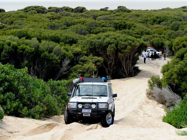 Police using four-wheel-drive vehicles to check the tracks along the dunes around the Salt Creek campsite.