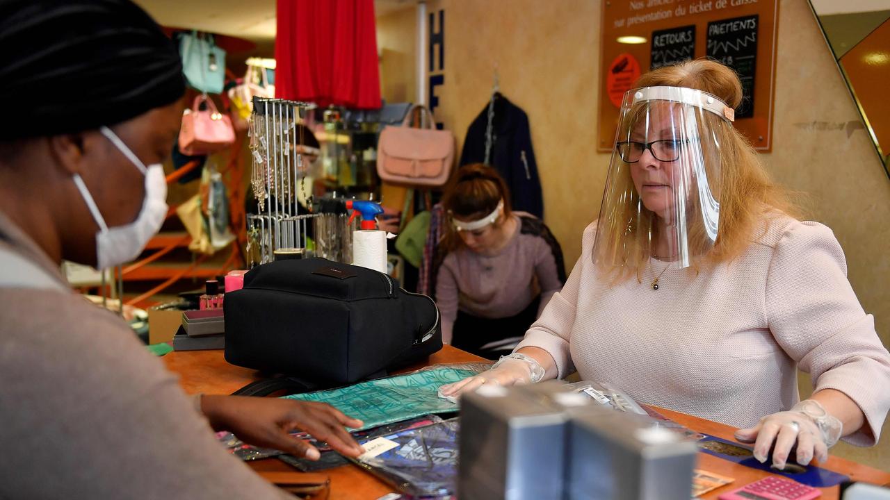 A cashier wearing a protective face shield speaks with a customer in a shop in Bordeaux, southwestern France on May 11. Picture: Georges Gobet/AFP