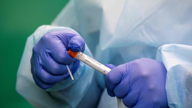 A health worker prepares to administer a swab test for Covid-19 at a walk-in portable testing centre operated by the ambulance service in Dublin, Ireland on March 25, 2021, as the country struggles to reduce the spread of coronavirus. (Photo by Paul Faith / AFP)