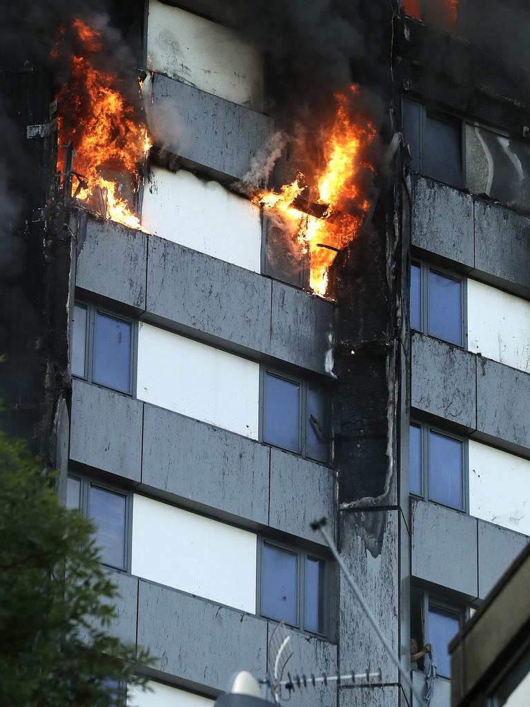 A person (bottom right) at a window of the building, as Metropolitan Police evacuate people from the tower. Picture: AP Photo/Matt Dunham