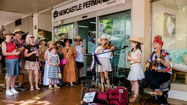 Sisters Tia (left) and Ellie Hannah, aged 11 and 9, performing with their mother Felicity Urquhart (right) on Peel Street in Tamworth. Picture: Antony Hands