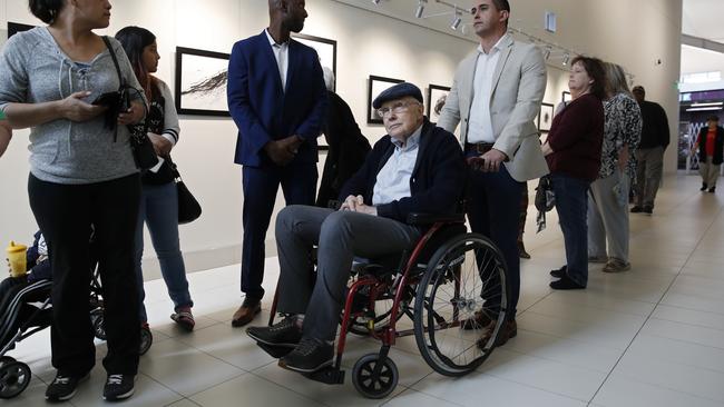 Former US Senator Harry Reid, centre, waits in line to vote at an early voting site at the East Las Vegas library.
