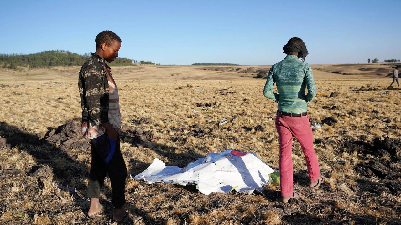 Local residents look at debris at the scene where Ethiopian Airlines Flight 302 crashed in a wheat field just outside the town of Bishoftu. Picture: Jemal Countess/Getty Images.