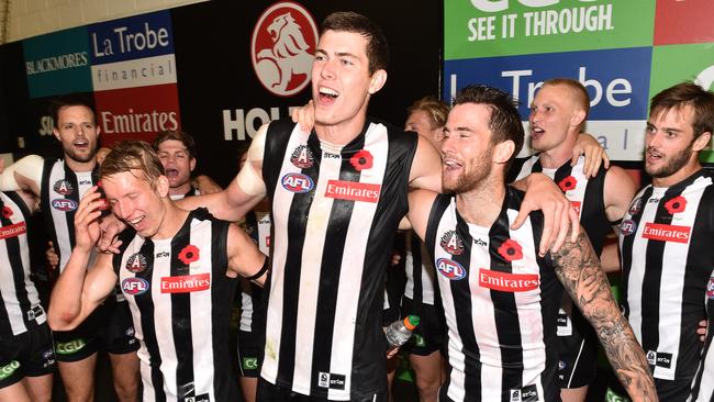 Josh Smith, Mason Cox and Jeremy Howe of the Magpies sing the club song after the Pies’ Anzac Day win. (AAP Image/Julian Smith)