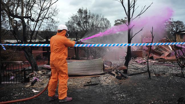 Hazmat crews spray asbestos bonding agent in Tathra, after homes were destroyed by fire, causing the release of the harmful building product into the atmosphere. Picture: Perry Duffin