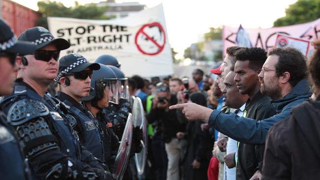 Police hold back protesters last night. AAP Image/Stefan Postles