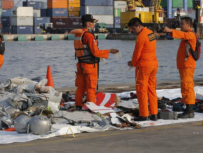 Indonesian Search and Rescue Agency crew inspect debris recovered from waters near the crash. Picture: AP/Tatan Syuflana