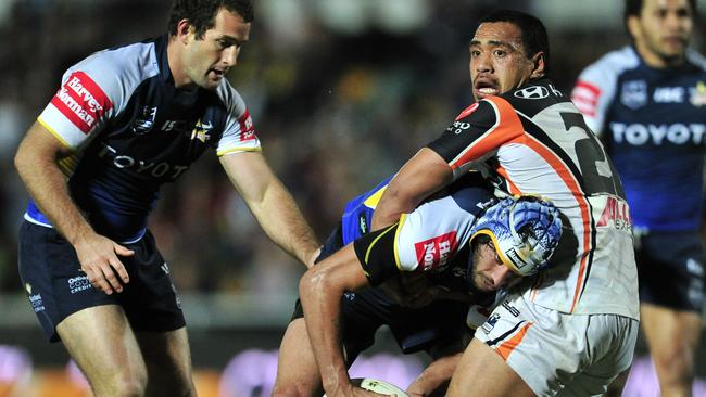 The North Queensland Cowboys’ Johnathan Thurston tackled by the Wests Tigers’ Masada Iosefa at Dairy Farmers Stadium in Townsville