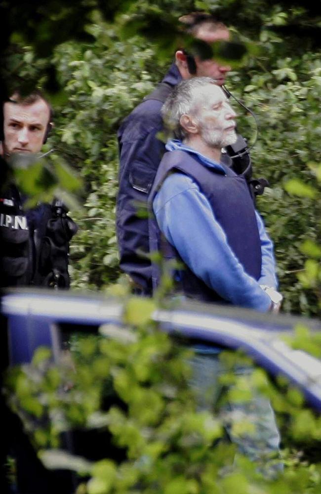 Under heavy police guard and wearing a bulletproof vest, Michel Fourniret leads investigators to two bodies in July 2004. AFP photo